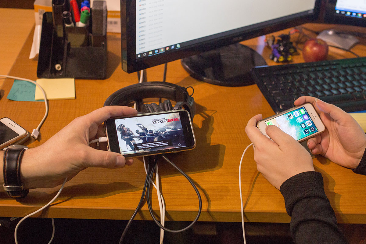Smartphones being held showing mobile games