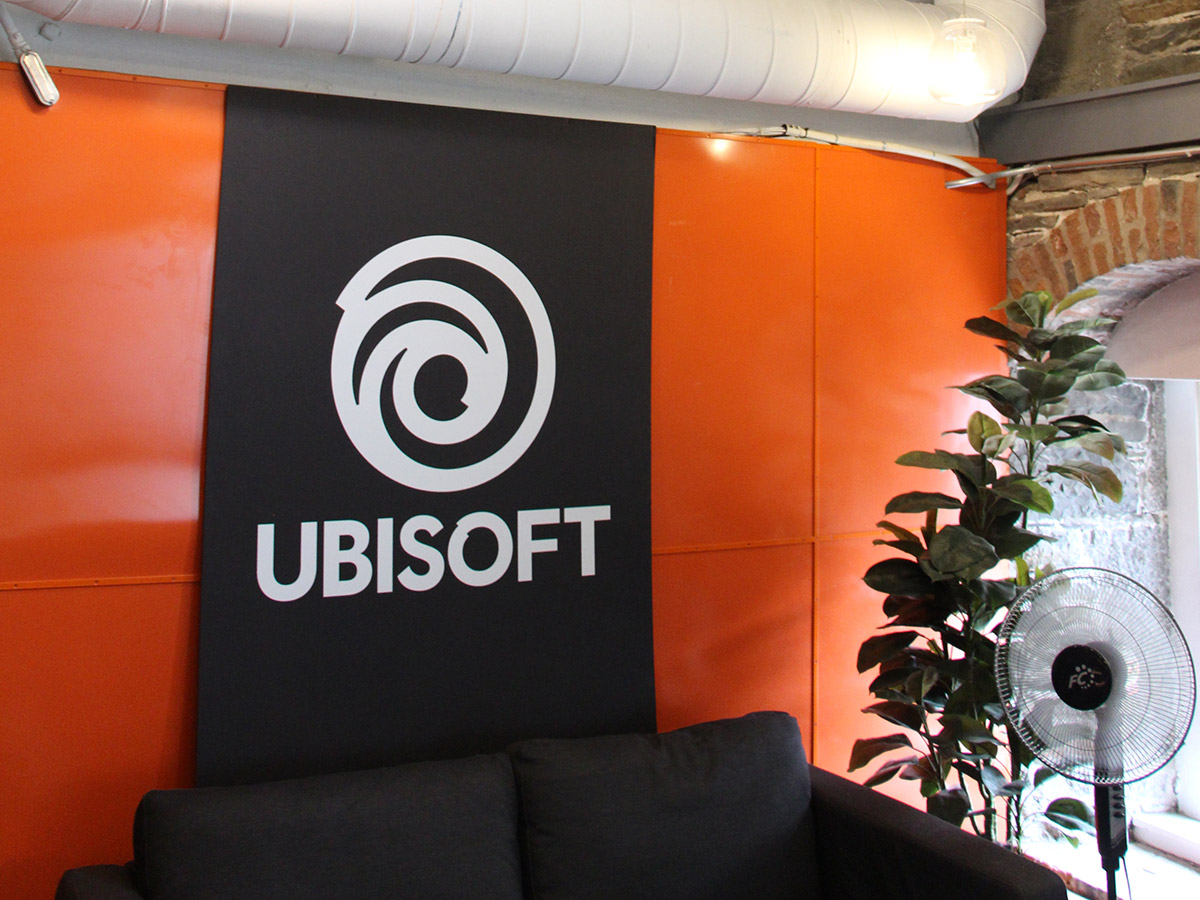 Two people working by a computer in Ubisoft Halifax game studio