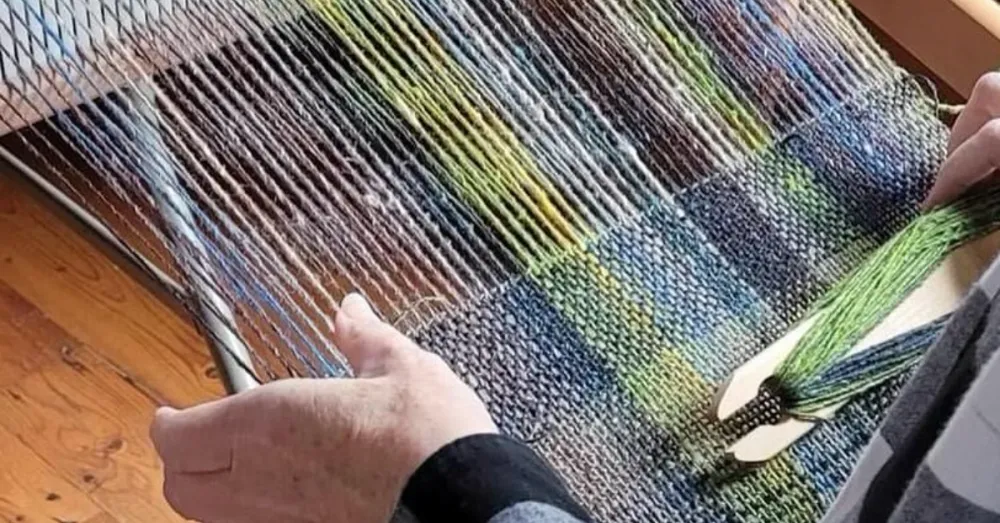 Woman weaving with Cotswold sheep wool