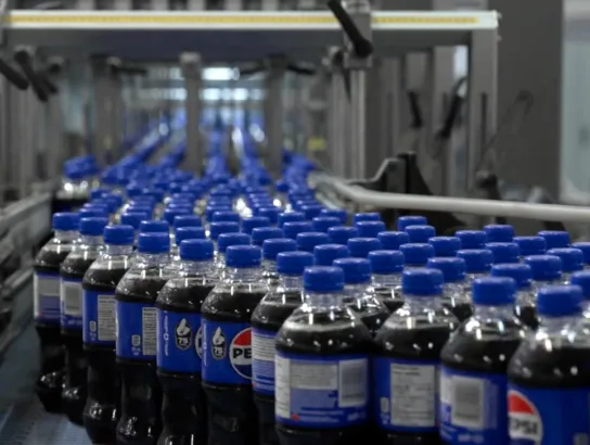 Pepsi in bottles on an assembly line
