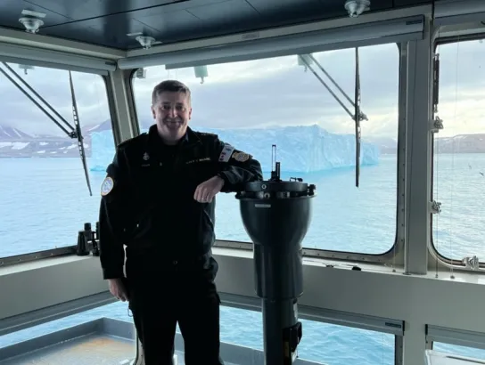 Sheldon posing in uniform on a navy vessel. 