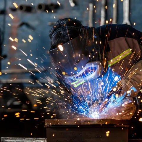 A professional welder wearing full protective gear.