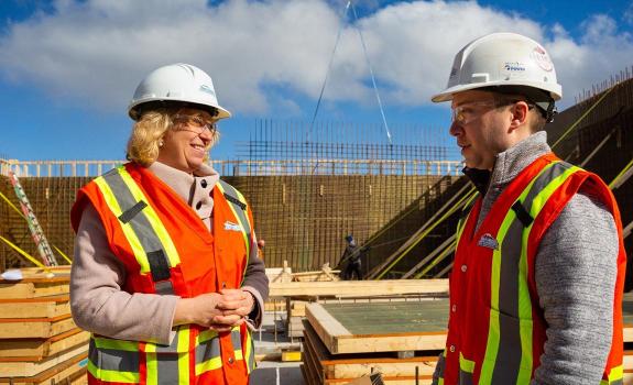 Laurel Broten, President and CEO of NSBI, speaks with a worker at a construction site in Nova Scotia.