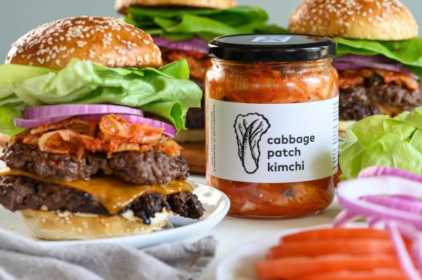 Hamburger in a bun with a bottle of kimchi