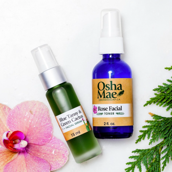 Soap and facial oil displayed with flower petals and foliage