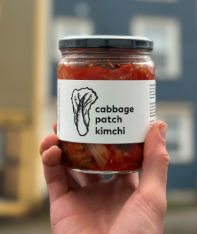 Bottle of kimchi being held by hand