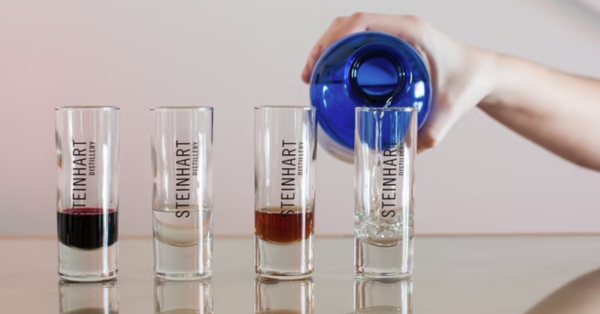 Man pouring gin into taster shot glasses