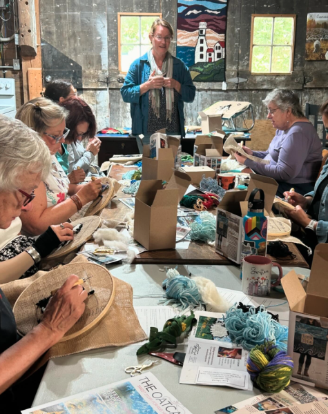 Group of students learning the art of rug hooking