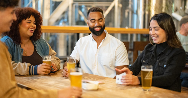 Group of people playing cards and drinking cider