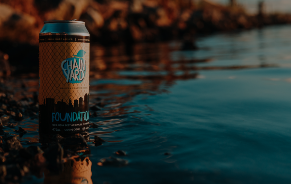 Can of Chain Yard Cidery cider poised at edge of ocean