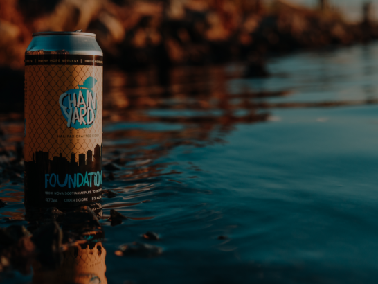 Can of Chain Yard Cidery cider poised at edge of ocean