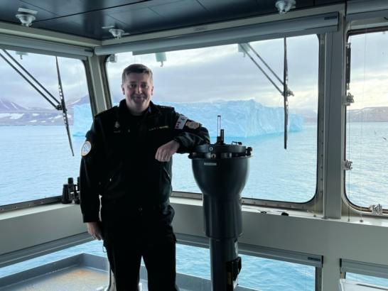 Sheldon posing in uniform on a navy vessel. 